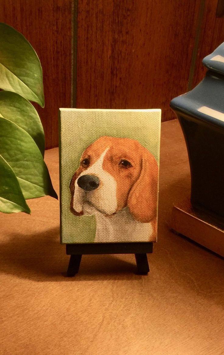 a card with a dog's face on it sitting next to a potted plant