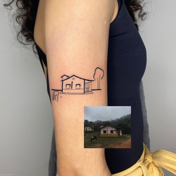 a woman's arm with a house and trees tattoo on the left side of her right arm