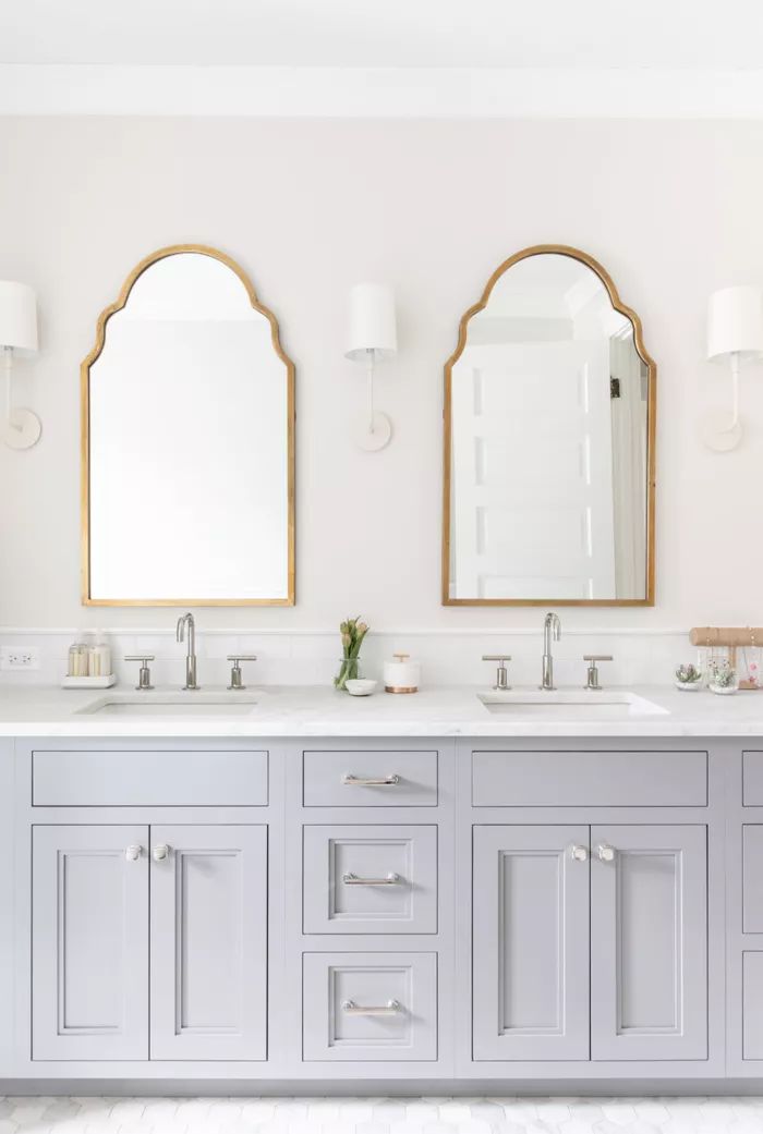 a bathroom with double sinks and two mirrors on the wall next to eachother