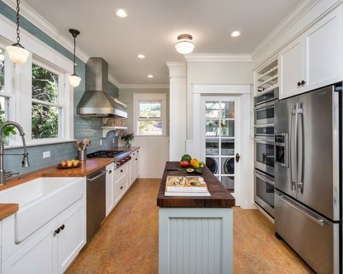 a kitchen with white cabinets and stainless steel appliances, along with wooden counter tops that match the hardwood flooring