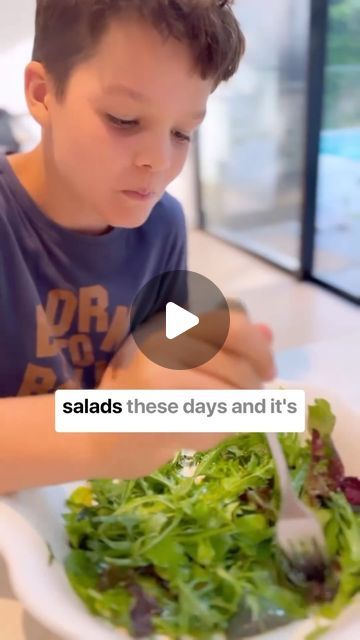 a young boy is eating salad with a fork in his hand and the caption reads salads these days and it's