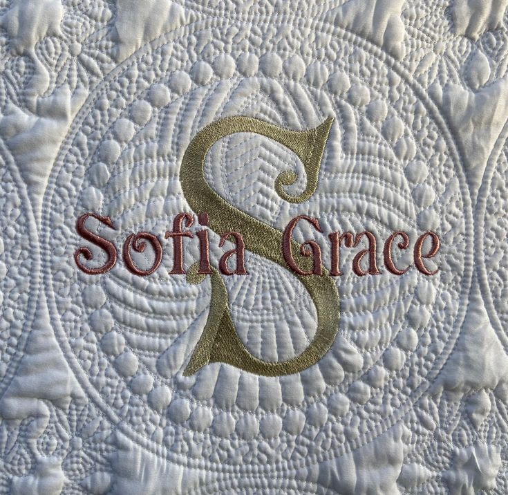 the logo for softa grace quilts is shown in red and gold on white