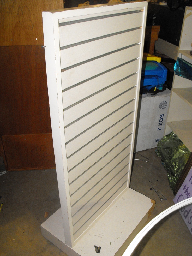 a white shelf sitting on top of a wooden floor next to a pile of boxes