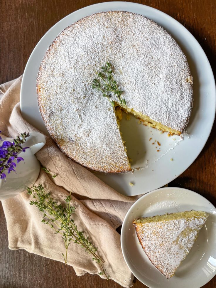 a cake on a plate with one slice cut out and the other half covered in powdered sugar