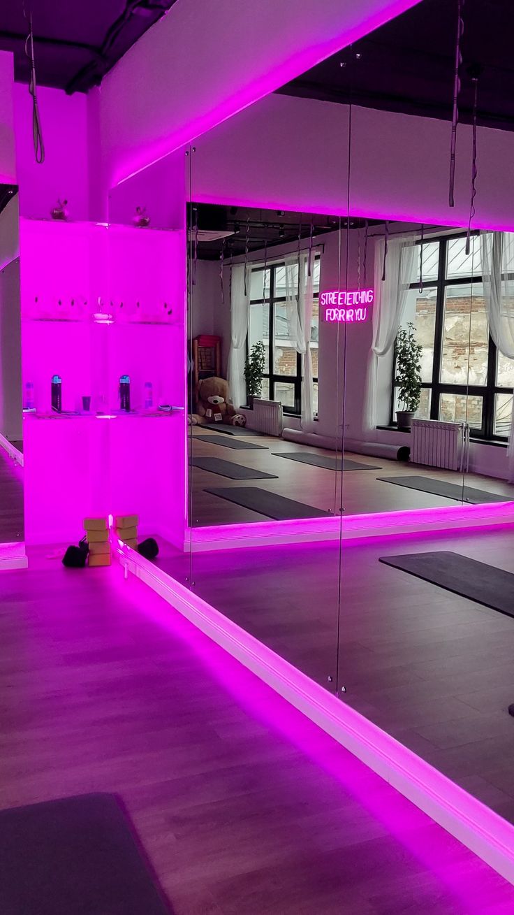 an empty gym room with mirrors and yoga mats