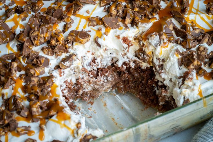 a chocolate cake with white frosting and caramel drizzled on top