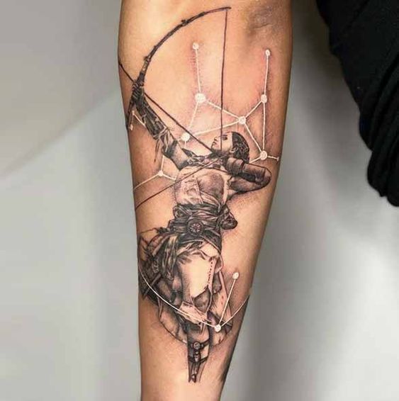 a person with a tattoo on their arm holding a bow and arrow in his hand