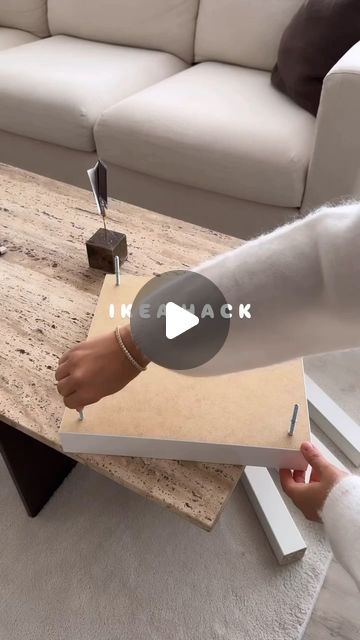 a person is holding a piece of cardboard in front of a coffee table that has been placed on top of it