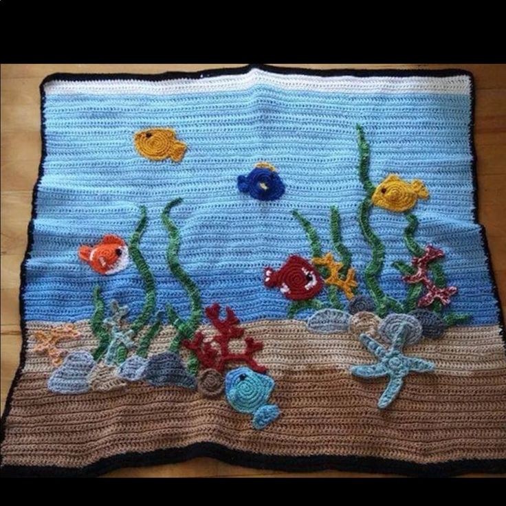 a crocheted blanket with fish and seaweed on the bottom, along with other marine creatures