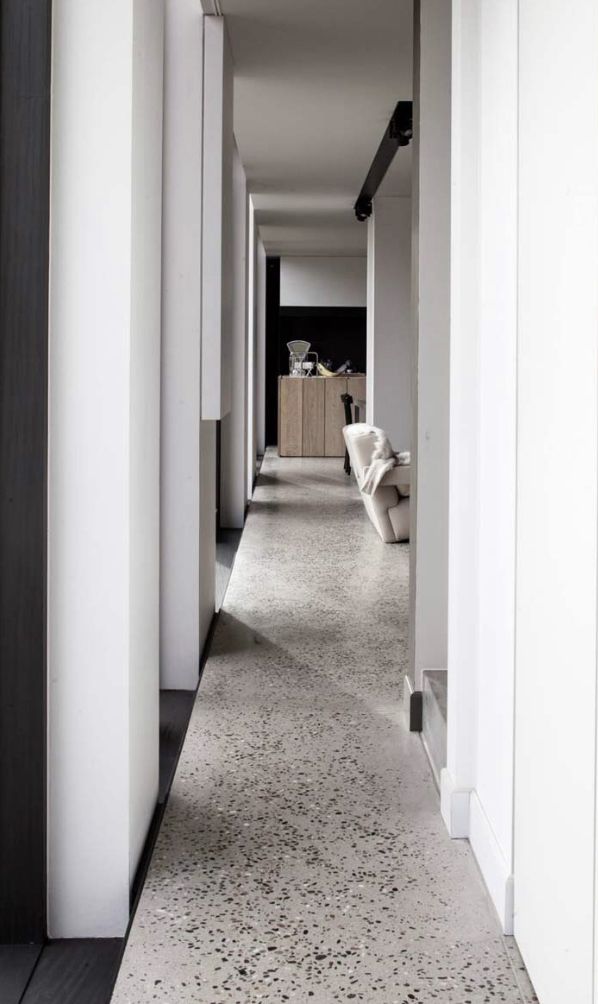 an empty hallway with white walls and flooring is seen in this image from the front door