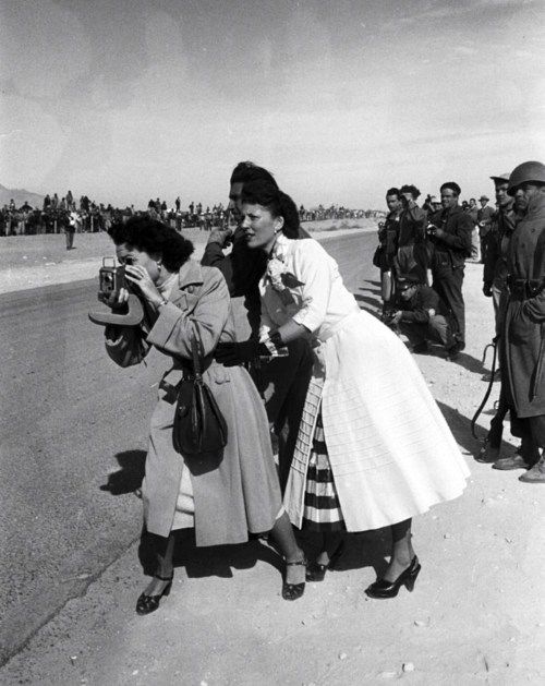 black and white photograph of two women standing on the side of an airport tarmac