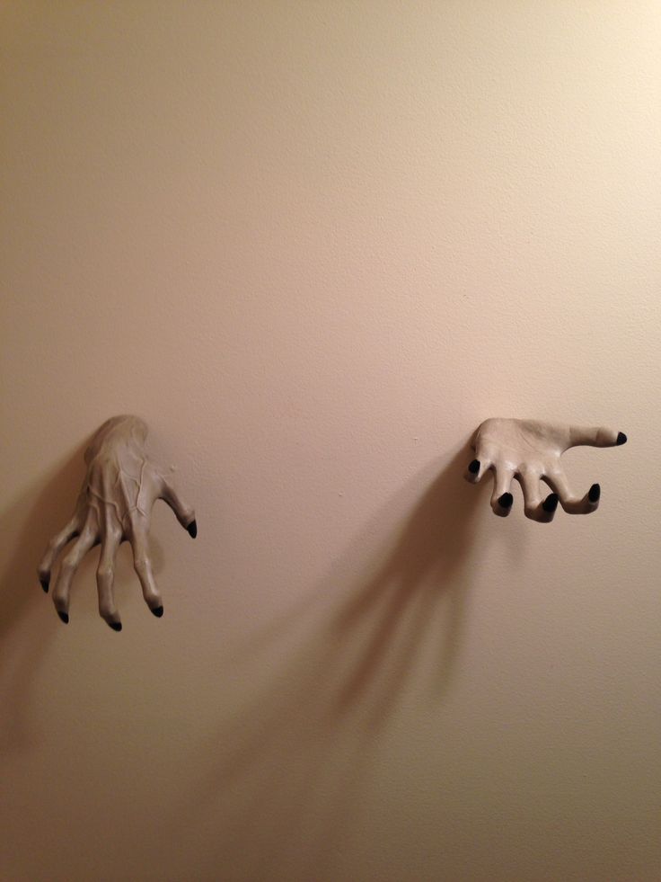 two fake hands are hanging on the wall