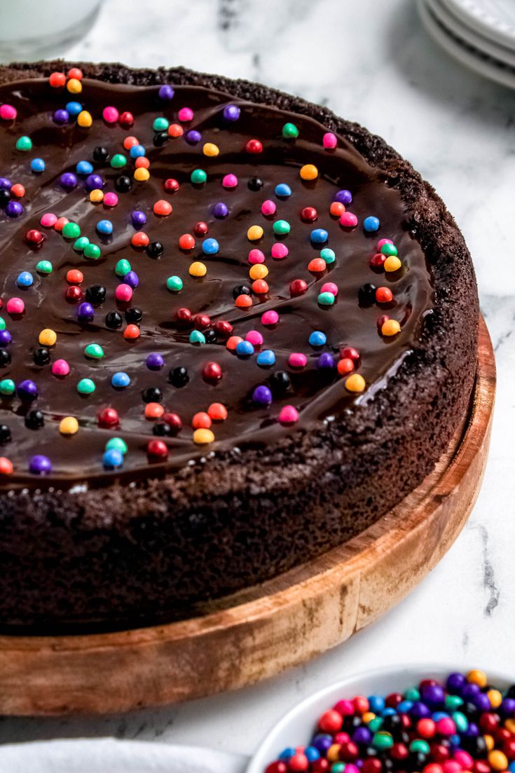 This Cosmic Brownie Cookie Cake is everything you want in a cookie, but in cake form! The base is a chewy, rich chocolate cookie topped with ganache and those classic rainbow sprinkles. Cosmic Brownie Pizza, Brownie Cookie Cake Recipe, Decorate Cookie Cake, Chewy Cookie Cake, Brownie Cookie Cake Birthday, Brownie Cakes For Birthday, Mini Cookie Cake Recipe, Cake Walk Cakes Ideas Simple, Cookie Cake Flavors