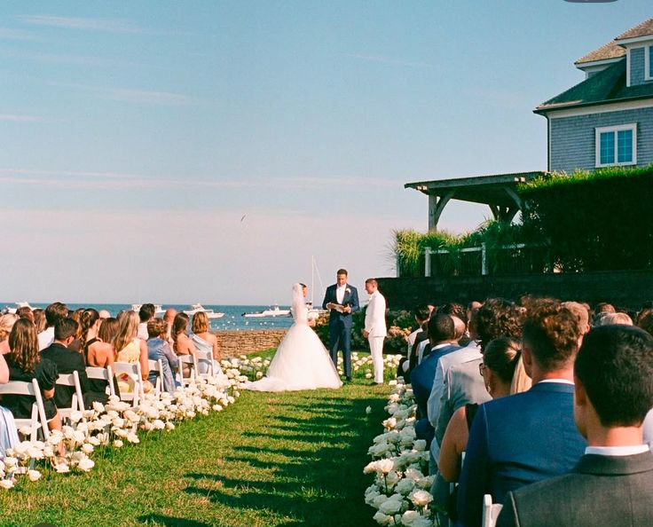 a bride and groom standing at the end of their wedding ceremony in front of an ocean view