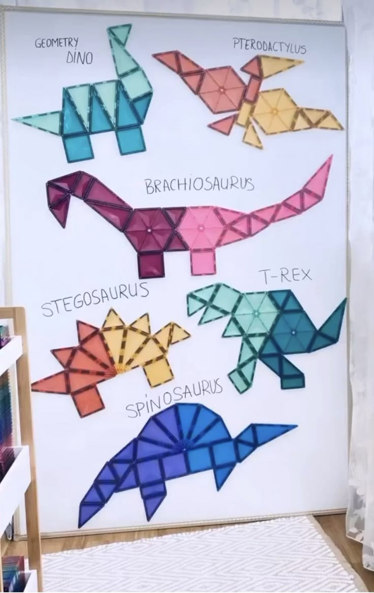 an image of origami dinosaurs in different colors on a white board with text