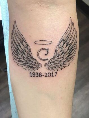 a black and white photo of a tattoo with wings on the leg that reads 5 year anniversary