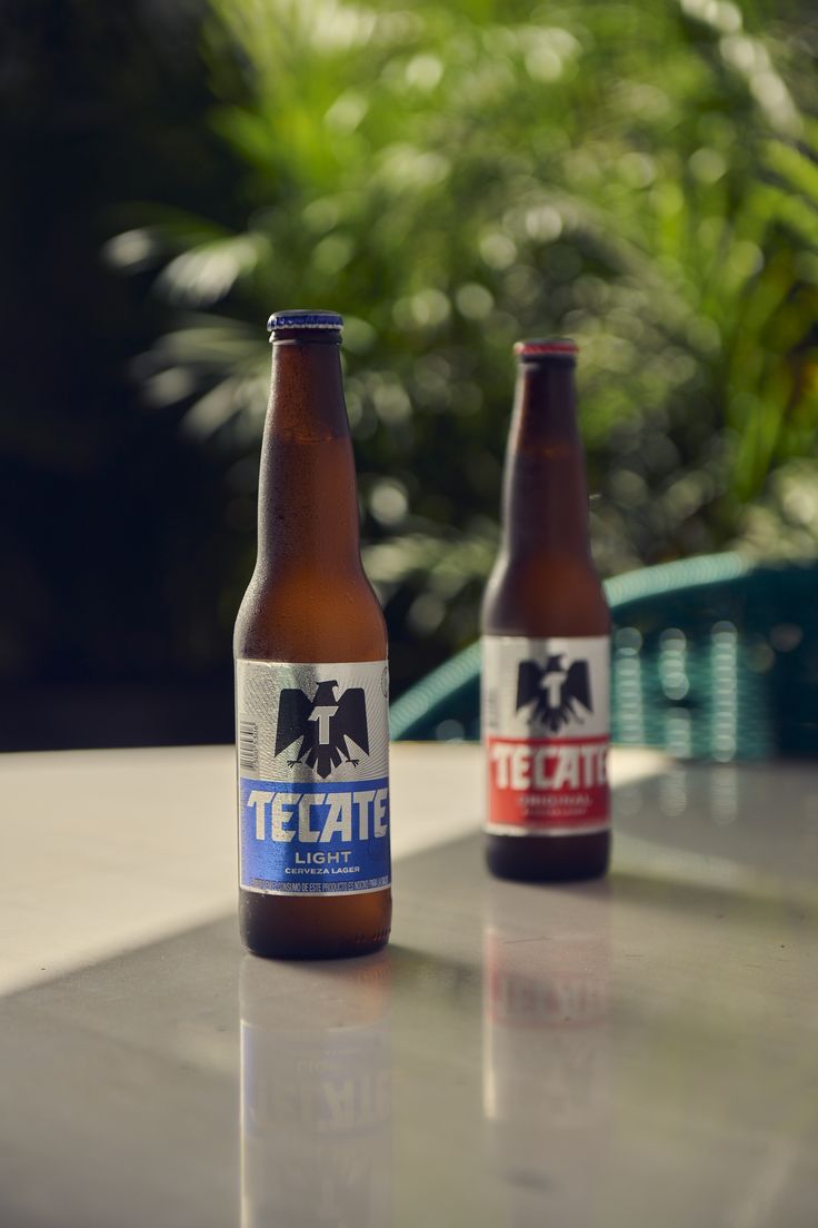 two beer bottles sitting on top of a table