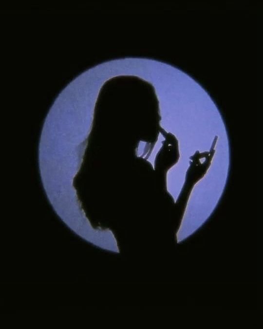 the silhouette of a woman holding a cell phone