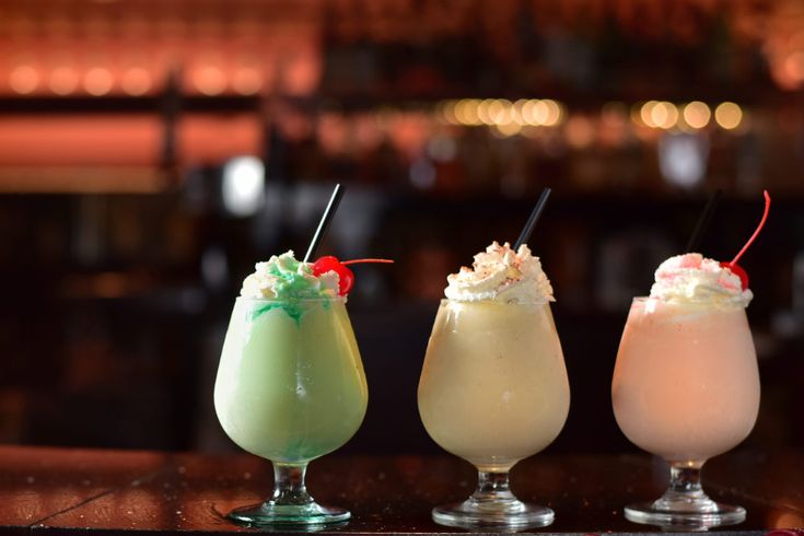 three different colored drinks sitting on top of a table