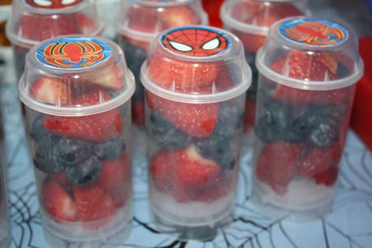 plastic containers filled with strawberries and blueberries in spider - man designs on them