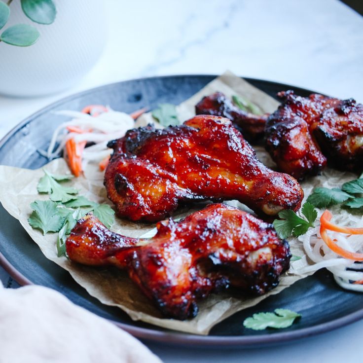 some chicken wings are on a plate with coleslaw and carrots