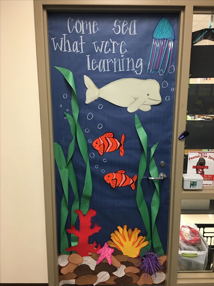 a door decorated with an ocean theme and some sea animals on the bottom, along with words that read come sea what were learning