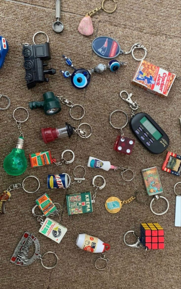 many different items are laid out on the floor to be used as keychains