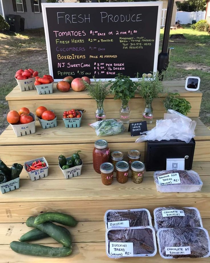 fresh produce is on display at the farmer's market in front of a sign