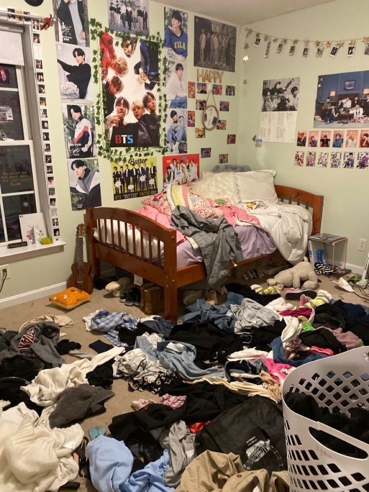 a messy bedroom with clothes scattered all over the floor and on the wall, in front of a bed