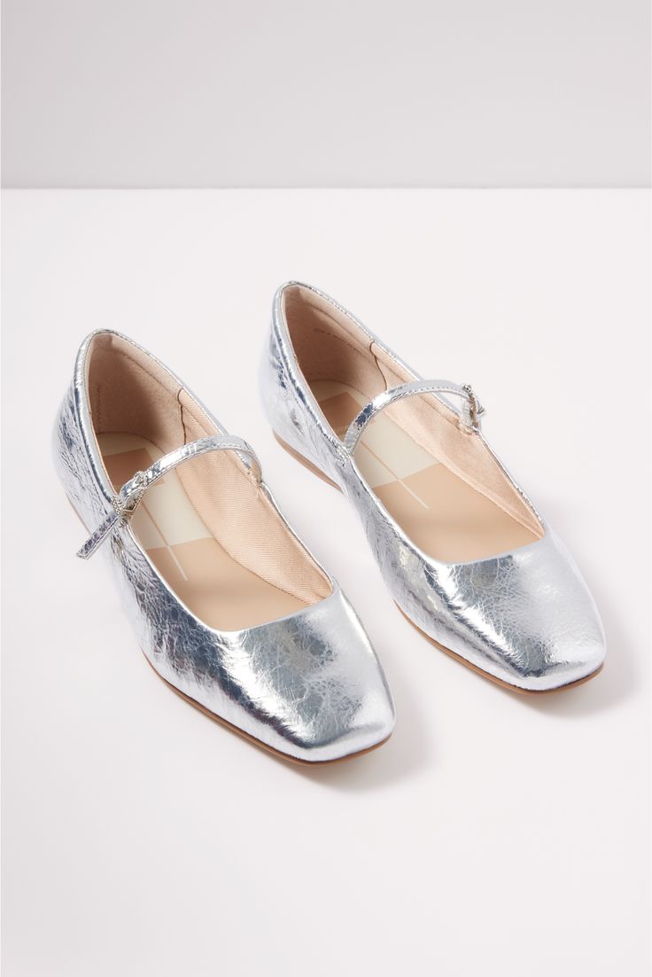 A chic, head-turning take on your classic ballet flat, the Reyes Mary Jane by Dolce Vita is finished in silver metallic leather with a square toe and adjustable strap. Style them from work to weekend with trousers, jeans, or a flowy maxi dress. Zapatos Mary Jane, Trousers Jeans, Flowy Maxi Dress, Dolce Vita Shoes, Shoe Size Conversion, Mary Jane Shoes, Ballet Flat, Metallic Leather, Mary Janes