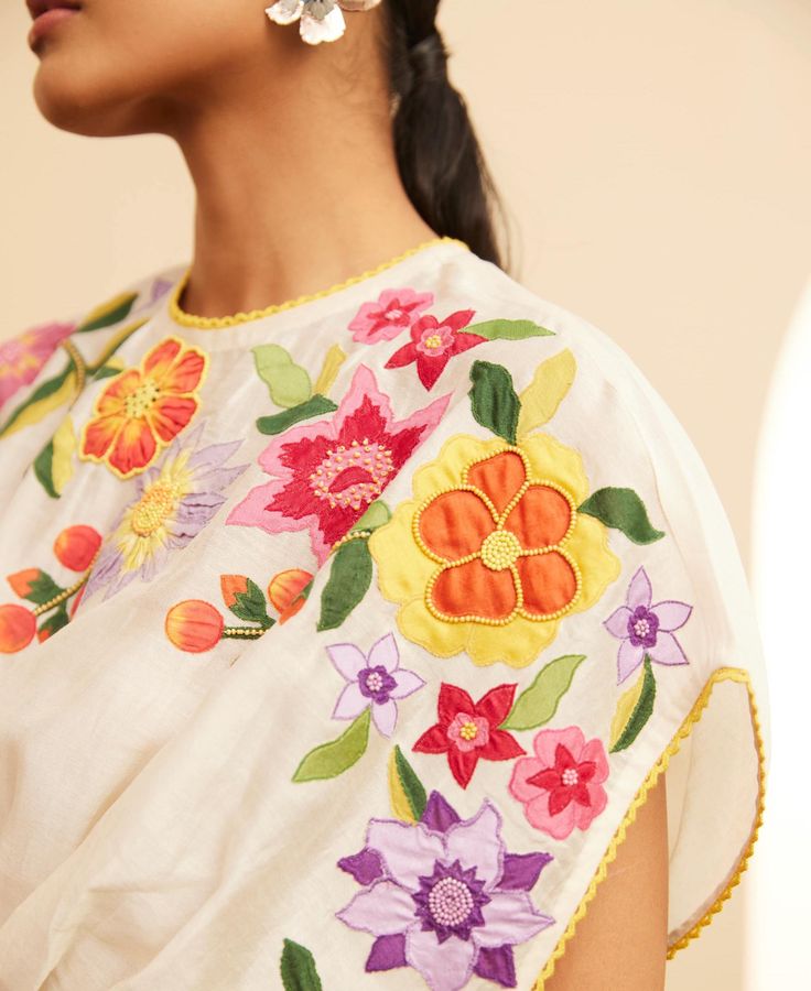 Editor's Note Featuring an ivory chanderi floral applique waist pleated top Color: Ivory Fabric: Chanderi Component: Top Occasion: Resort and daywear Care: Dry Clean Only About the Designer Chandrima celebrates diversity in cultures and craft forms creating ready-to-wear women wear for the urban woman of today. The brand embodies the idea of Indian handloom and craft merged with an international style. Label Chandrima stands for modern elegance and craftsmanship stemmed from the diversity and un Luxury Designer Tops With Intricate Embroidery, Luxury Party Wear Tops With Resham Embroidery, Luxury Designer Top With Intricate Embroidery, Luxury Traditional Tops With Printed Motifs, Luxury Summer Traditional Wear With Floral Embroidery, Luxury Designer Wear Tops For Festive Season, Luxury Embroidered Top For Puja, Luxury Embroidered Top For Diwali Party, Luxury Embroidered Top For Diwali Festive Occasions