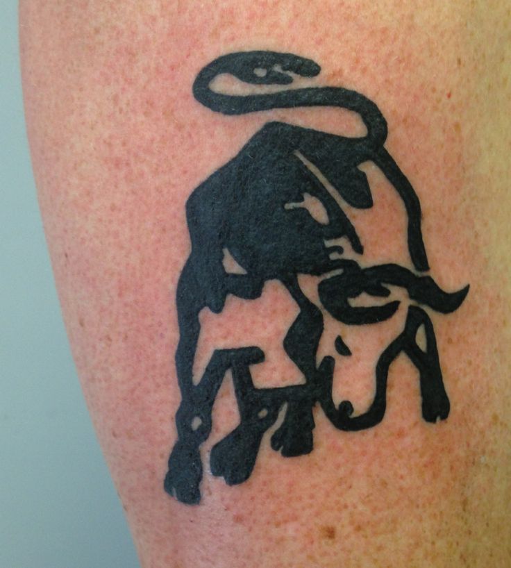 a tattoo on the leg of a man with a bull