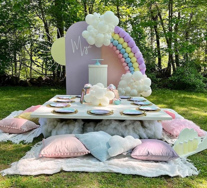 a table set up with balloons and pillows