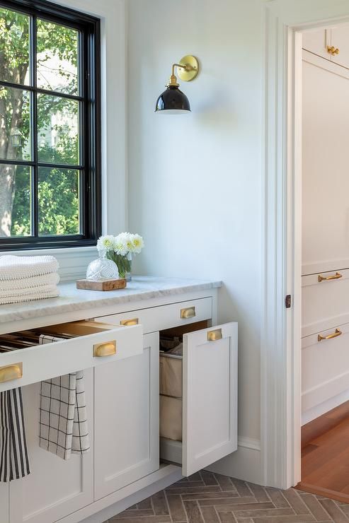 a kitchen with white cabinets and gold pulls