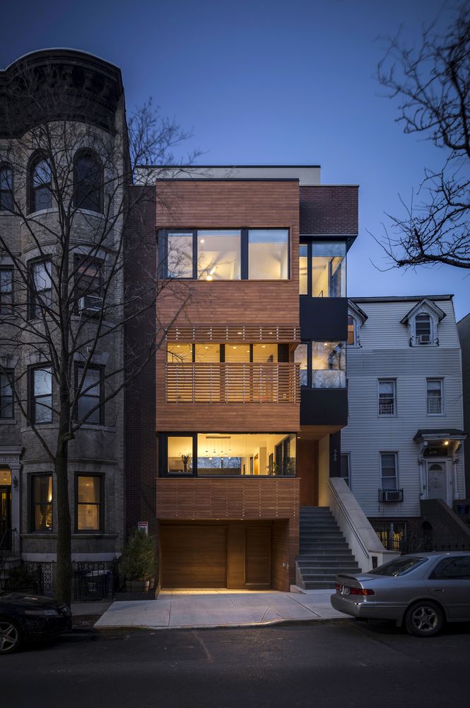 an apartment building at night with cars parked on the street and stairs leading up to it