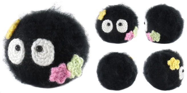 four black crocheted balls with white eyes and pink flowers on them, each containing an individual's own face