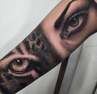 a tiger eye tattoo on the left forearm and right arm with an eyeball in it