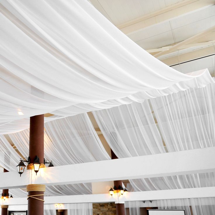 the ceiling is covered with white drapes