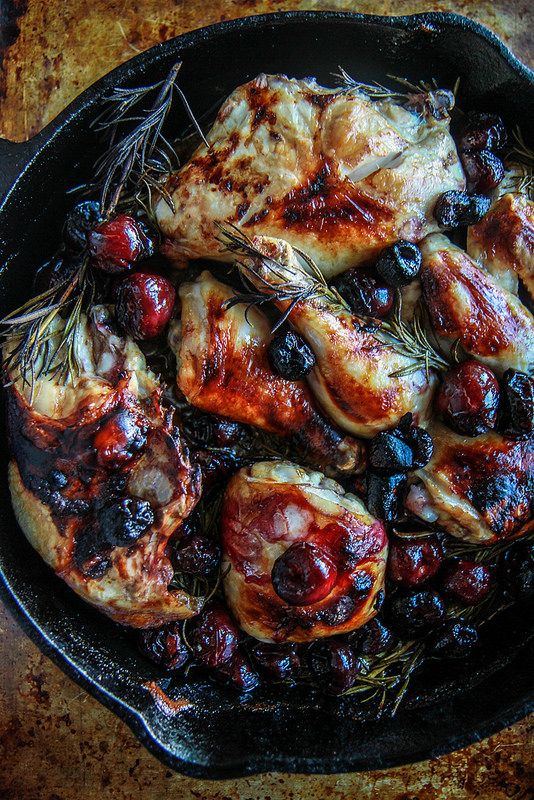 chicken with cherries and rosemary in a cast iron skillet