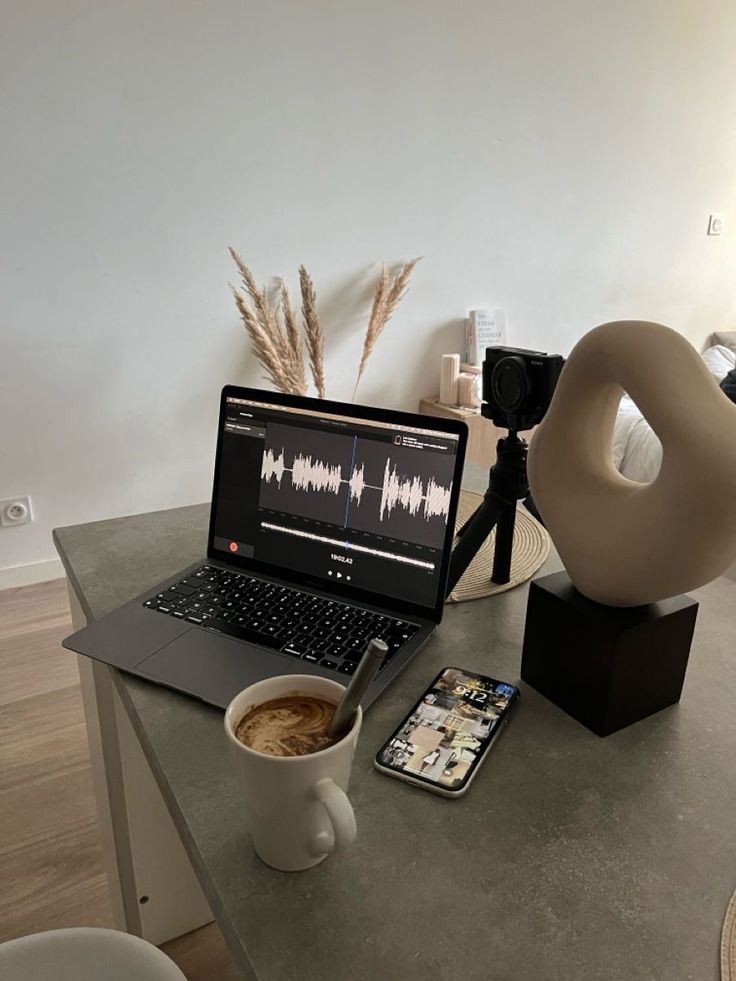 an open laptop computer sitting on top of a table next to a cup of coffee