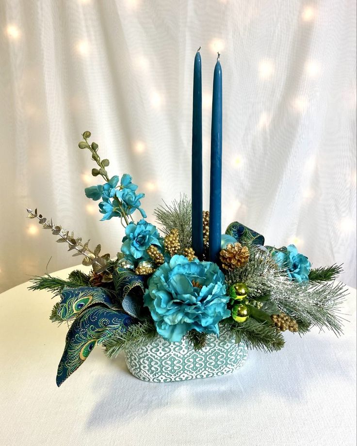 a centerpiece with blue flowers and candles