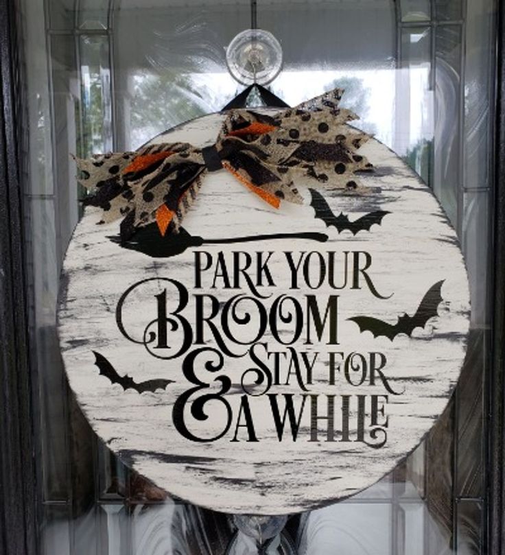 a wooden sign that says park your broom and stay for a while on the front door