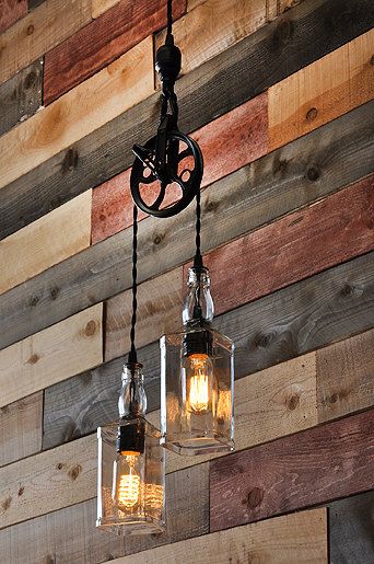 two mason jar chandeliers hanging from a wooden wall