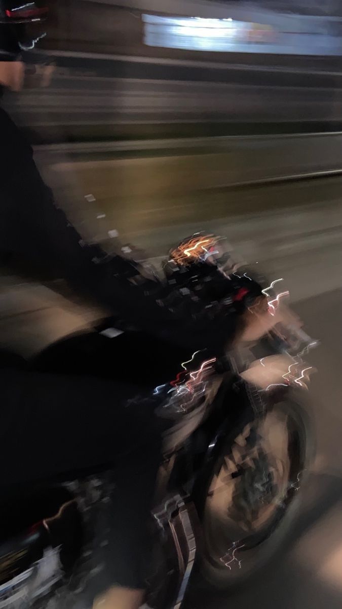 a man riding a motorcycle down a street at night