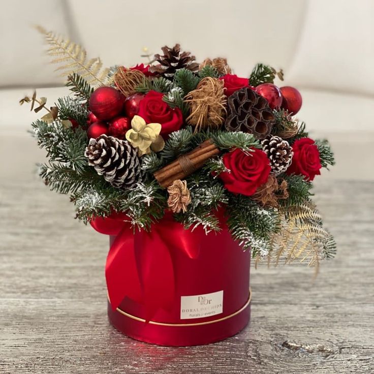 a christmas arrangement in a red box on a table