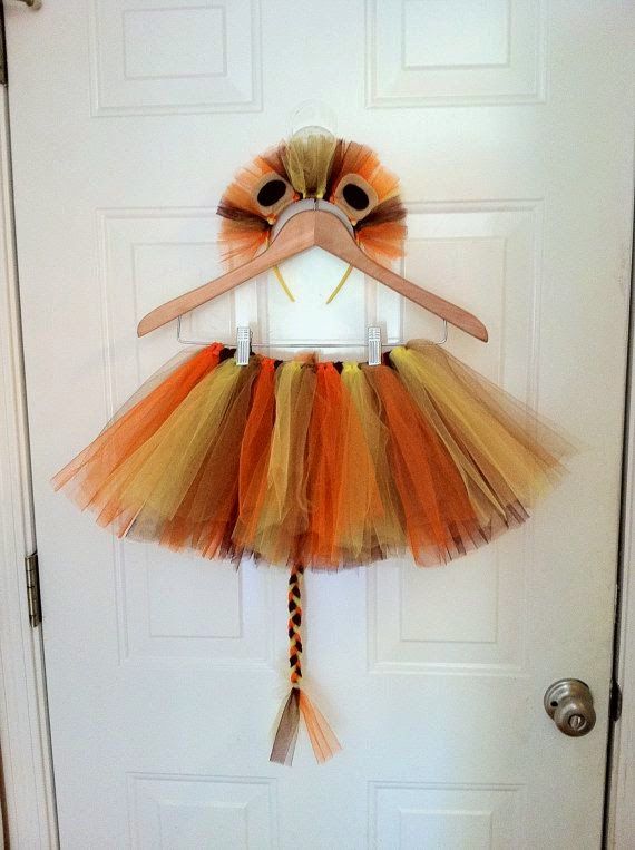 an orange and yellow tutu skirt hanging on a door hanger in front of a white door