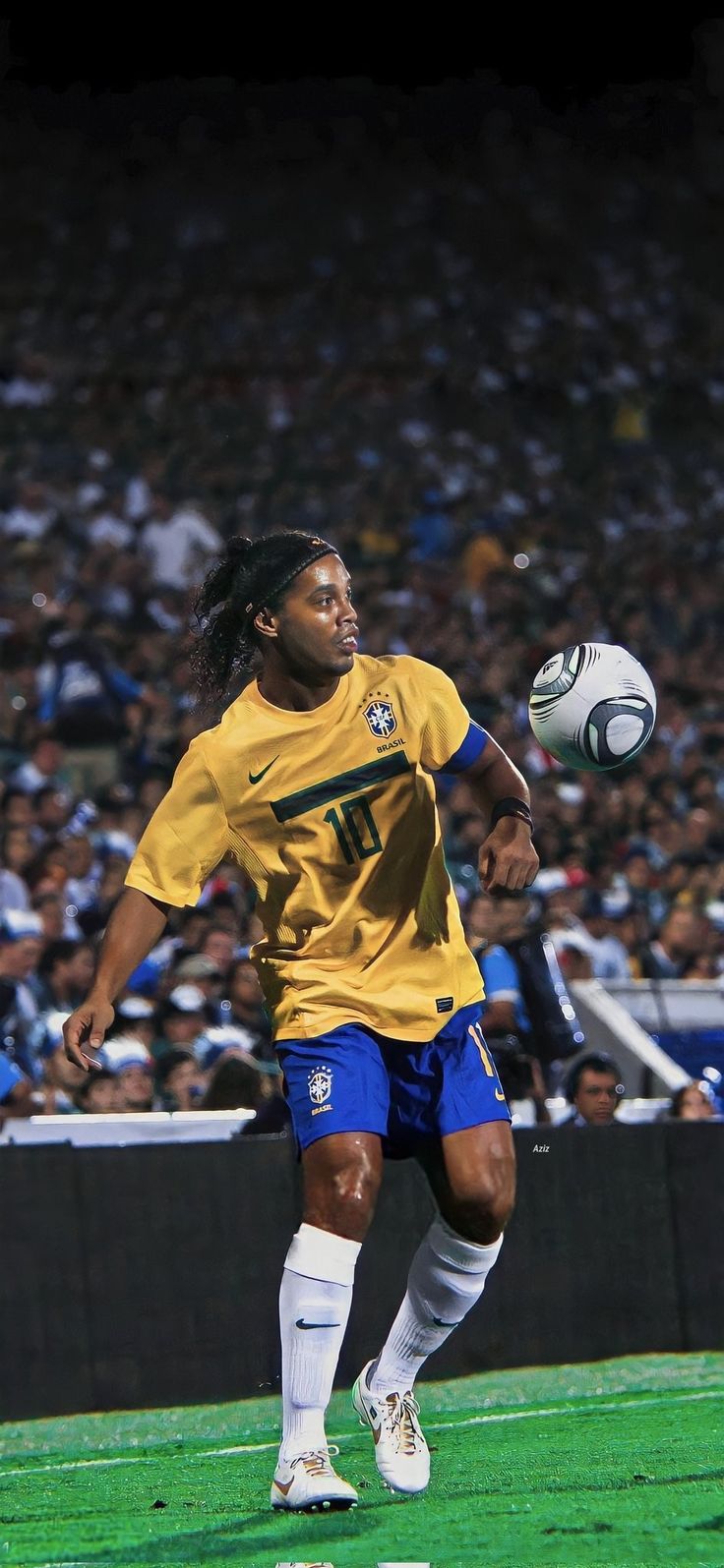 a man kicking a soccer ball on top of a field