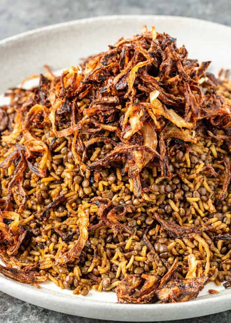 a white bowl filled with brown rice and other food items on top of a table