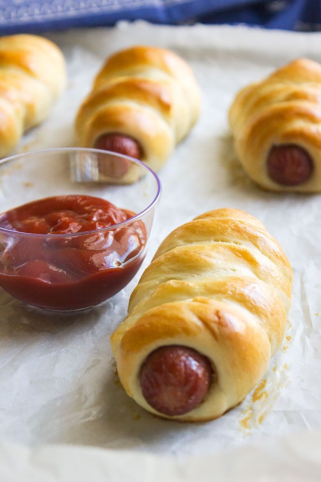 hotdogs wrapped in bread with ketchup on the side