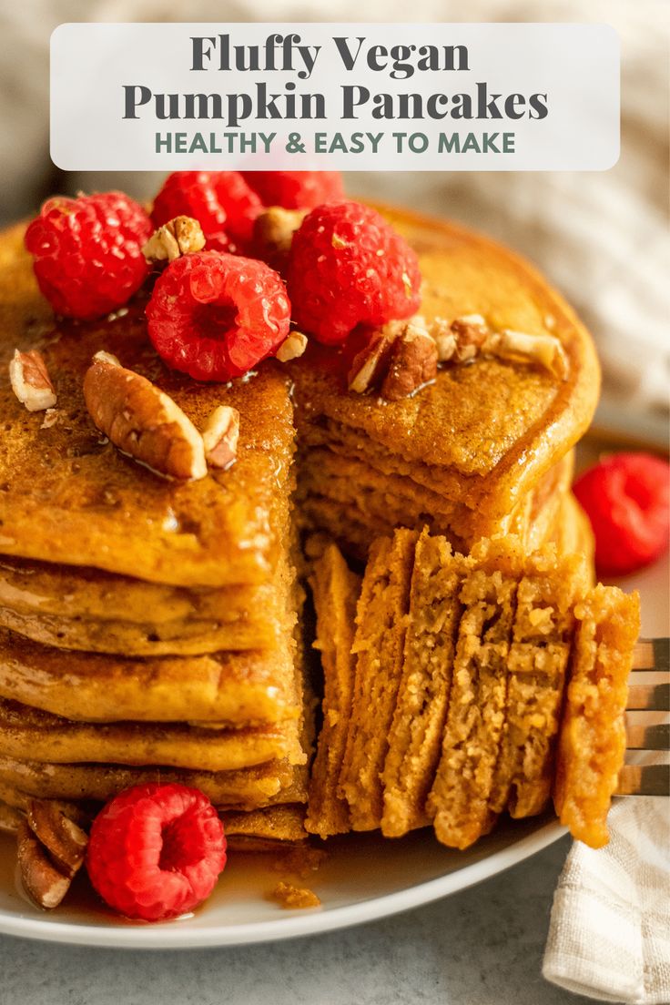 a stack of fluffy vegan pumpkin pancakes on a plate with raspberries